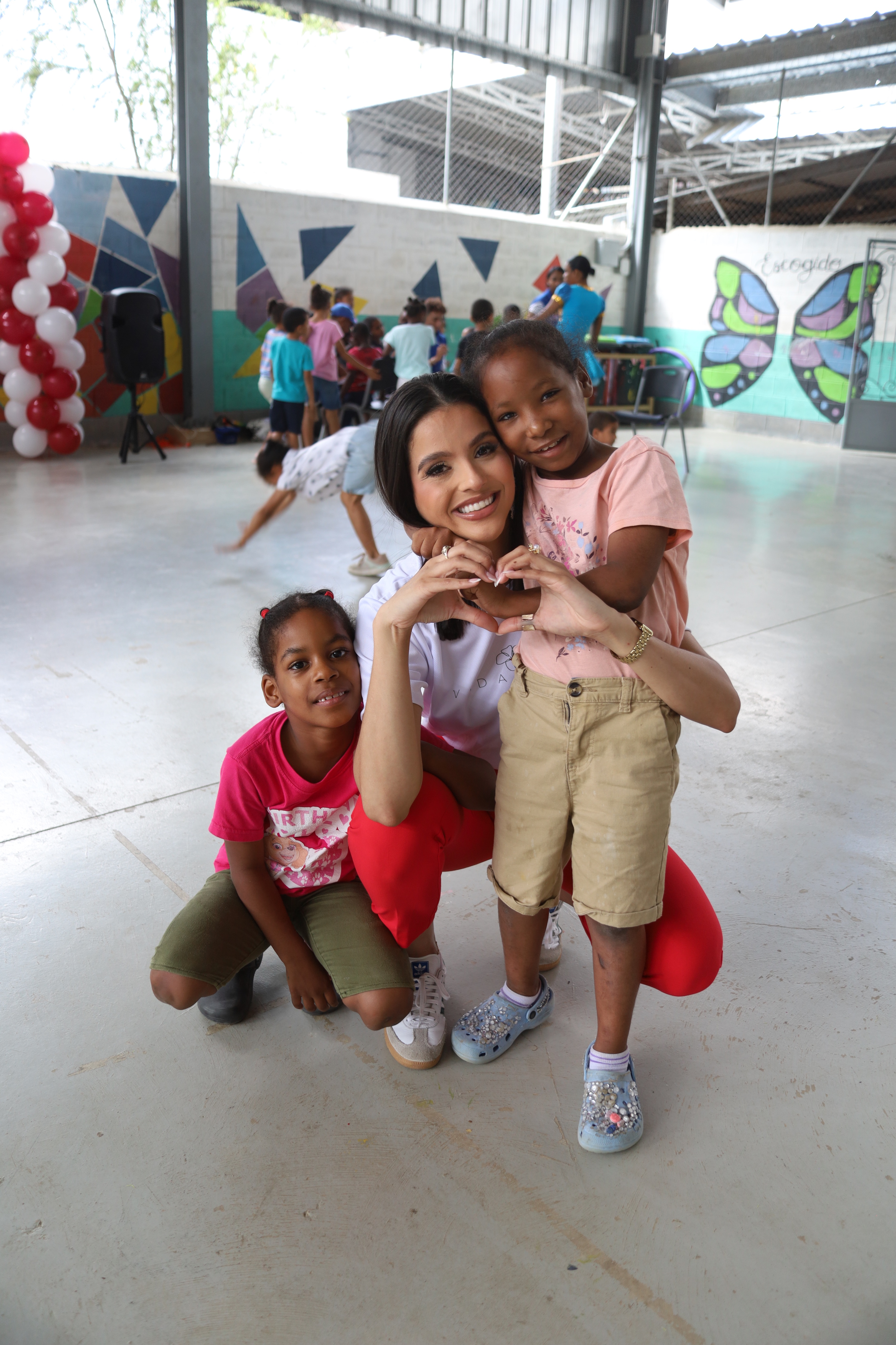 Vida Mana volunteer making heart hands with children at Red Misericordia